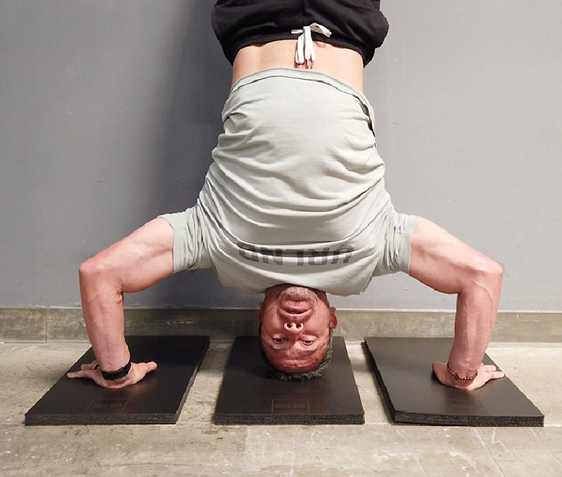 Guy doing handstand push ups on risers 3 pack